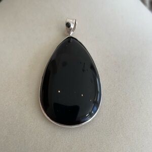 2” long pear shaped black onyx pendant. Trimmed in silver. New